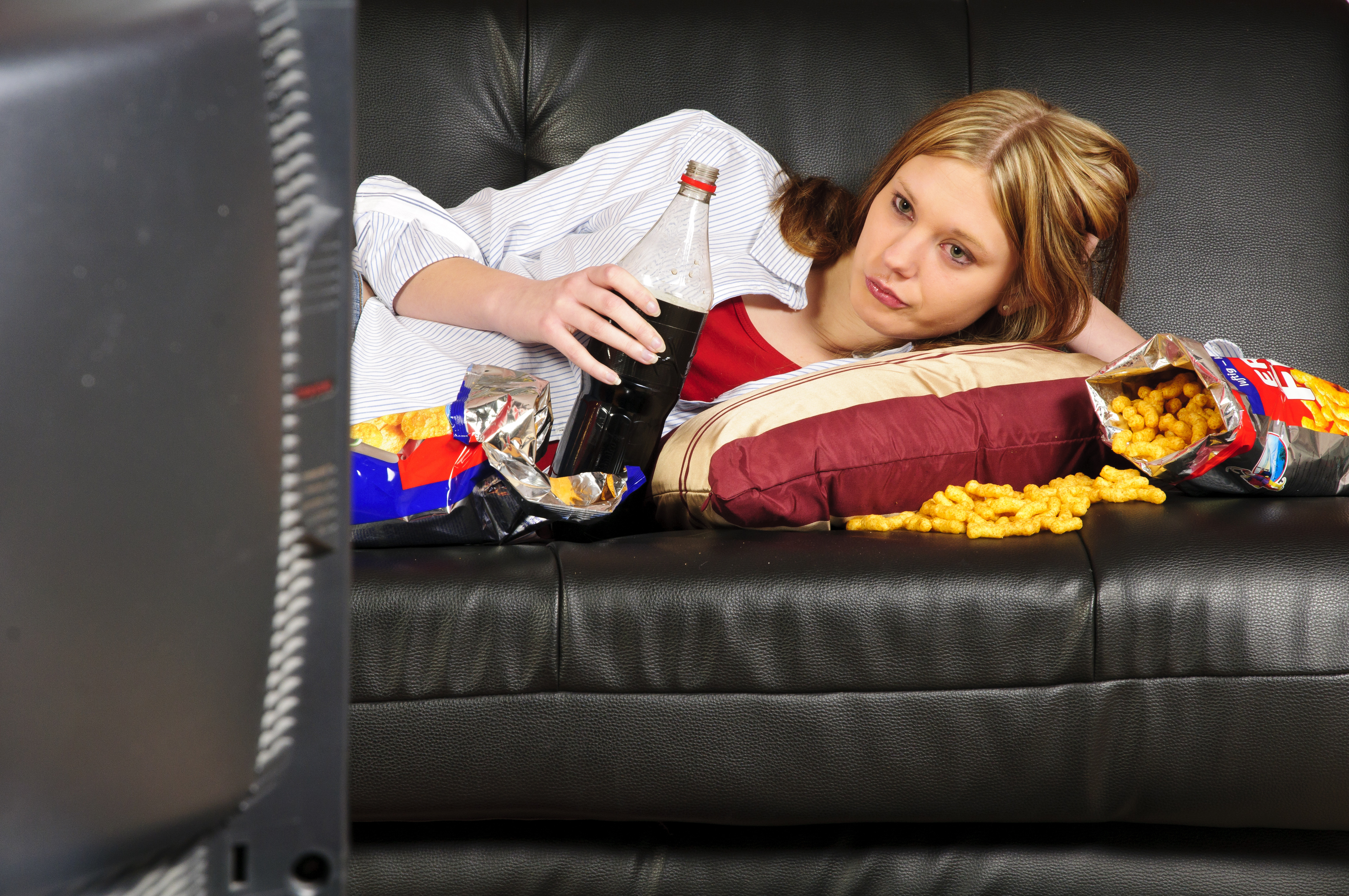 Лениво заметила. Женщина перед телевизором. Ленивая девушка. Женщина лежит на диване. Девушка лежит на диване с чипсами.